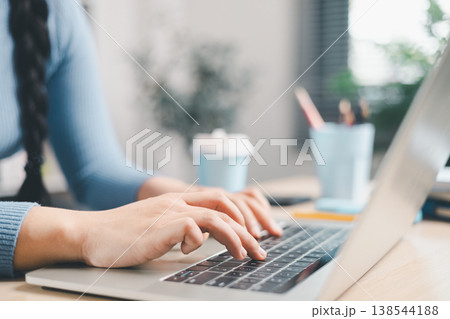 Close up of woman typing on laptop keyboard at home desk. Remote work, online learning, digital communication, productivity and modern workspace lifestyle concept for business and study. Close up of woman typing on laptop keyboard at home desk. Remote work, online learning, digital communication, productivity and modern workspace lifestyle concept for business and study. 138544188
