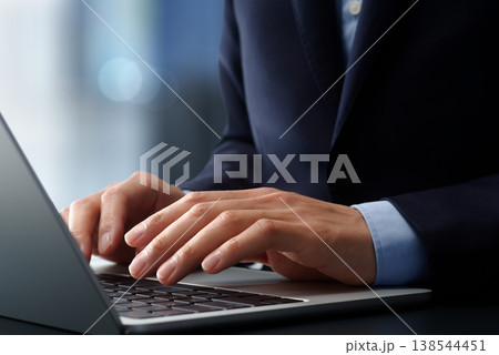 オフィスのデスクでノートパソコンを使うビジネスパーソン。手とキーボードのクローズアップ。ビジネスでの オフィスのデスクでノートパソコンを使うビジネスパーソン。手とキーボードのクローズアップ。ビジネスでの 138544451