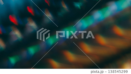 Striped defocused glow. Leak prism. Kaleidoscopic pattern light reflection on black. Orange green red color crystal lens texture abstract background. Striped defocused glow. Leak prism. Kaleidoscopic pattern light reflection on black. Orange green red color crystal lens texture abstract background. 138545299