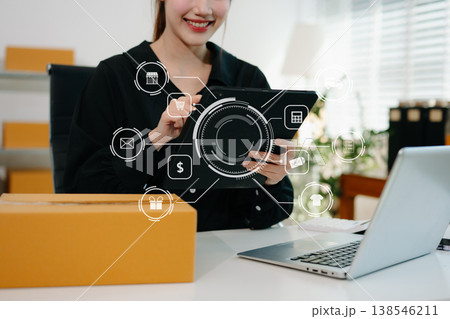 Woman hand using a laptop, smartphone and tablet and writing notebook at the office of her business online shopping. In home with virtual icon 138546211