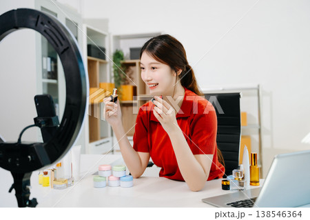 The scene highlights asian woman demonstrating lipstick and cosmetics for beauty advertising and ecommerce, reflecting modern content creation in a clean indoor studio environment. The scene highlights asian woman demonstrating lipstick and cosmetics for beauty advertising and ecommerce, reflecting modern content creation in a clean indoor studio environment. 138546364