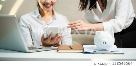 Smiling couple managing savings and budget at home with piggy bank, laptop and calculator. Personal finance, investment planning and smart money management Smiling couple managing savings and budget at home with piggy bank, laptop and calculator. Personal finance, investment planning and smart money management 138546564