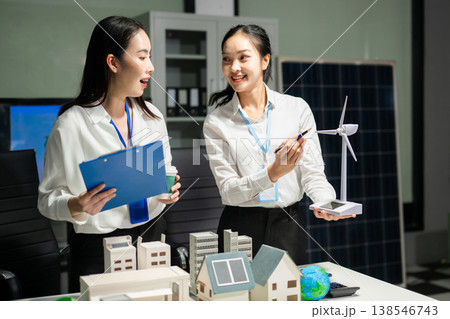 Business professionals planning renewable energy strategy with solar panels and wind turbine model. Sustainability, ESG, green innovation and net zero 138546743