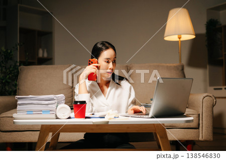 Asian woman using calculator for financial accounting and tax return at night home office. Asian woman using calculator for financial accounting and tax return at night home office. 138546830