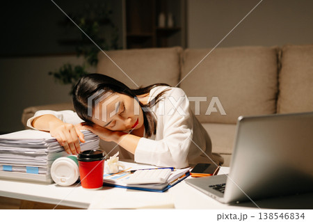 Asian woman using calculator for financial accounting and tax return at night home office. 138546834