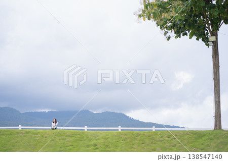 Relax and wellness concept with woman sit on road in garden and mountain background at chiangmai thailand in raining season 138547140