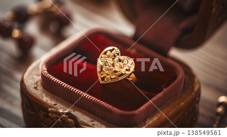 golden heart-shaped ring with delicate floral designs, placed in an open velvet box on the table, exuding romantic charm and exquisite craftsmanship golden heart-shaped ring with delicate floral designs, placed in an open velvet box on the table, exuding romantic charm and exquisite craftsmanship 138549561
