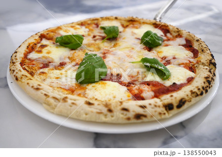 Delicious Hot Margherita Pizza on White Plate with Marble Background 138550043