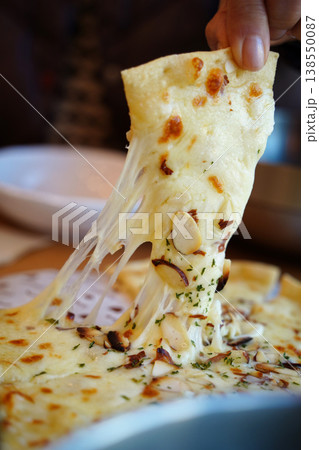 lose-up of Cheesy Pizza Slice Being Pulled with Long Cheese Strings lose-up of Cheesy Pizza Slice Being Pulled with Long Cheese Strings 138550087