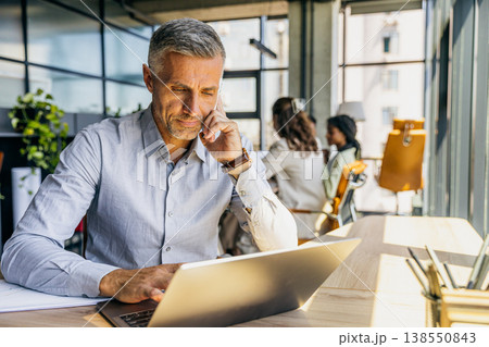 Focused agent examining documents while engaging with clients 138550843