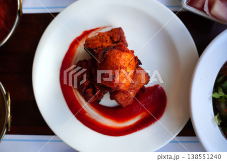 Authentic Indian Chicken Tikka served with spicy red sauce on a white plate. 138551240