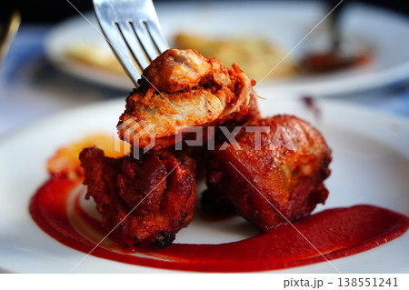 Authentic Indian Chicken Tikka served with spicy red sauce on a white plate. Authentic Indian Chicken Tikka served with spicy red sauce on a white plate. 138551241