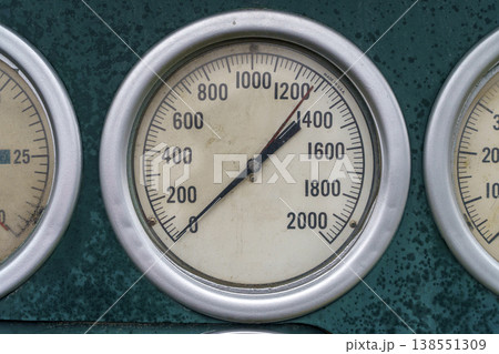 Industrial Analog Pressure Gauges Mounted on Green Control Panel Surface 138551309