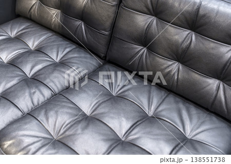 Black Quilted Leather Sofa Corner Close Up with Soft Cushioned Texture Details 138551738
