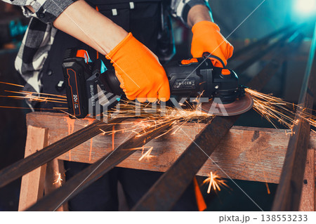 A man cuts metal using an angle grinder. Many sparks A man cuts metal using an angle grinder. Many sparks 138553233