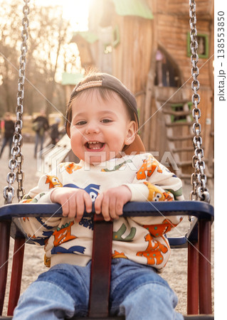 Toddler Enjoying Bucket Swing at Outdoor Playground Toddler Enjoying Bucket Swing at Outdoor Playground 138553850