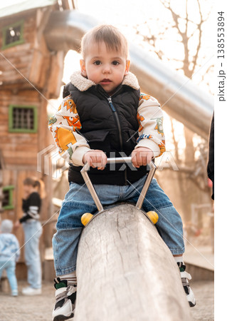 Toddler Riding Playground Rocker in Park at Sunset Toddler Riding Playground Rocker in Park at Sunset 138553894