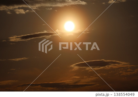 白く輝く夕陽とオレンジ色の染まる夕焼け空と雲の風景 白く輝く夕陽とオレンジ色の染まる夕焼け空と雲の風景 138554049