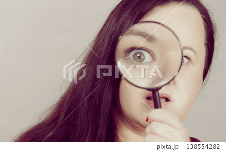 Adult woman with magnifying glass 138554282