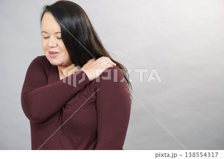Woman with pain in shoulder Woman with pain in shoulder 138554317
