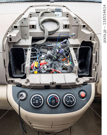 Car dash wiring. Open car dashboard revealing tangled wiring and audio system modifications Car dash wiring. Open car dashboard revealing tangled wiring and audio system modifications 138554614