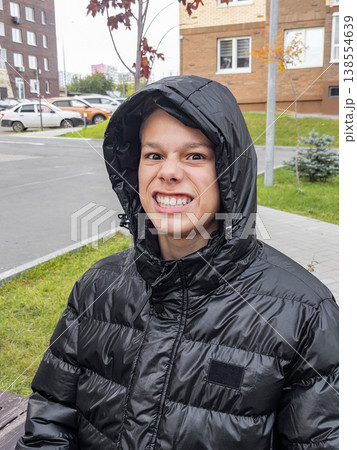 Youthful street excitement. Vibrant teenage individual displaying playful street fashion and confidence Youthful street excitement. Vibrant teenage individual displaying playful street fashion and confidence 138554639