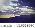雲の隙間から見える光と街並みシルエット 138554960