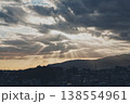 雲の隙間から見える光と街並みシルエット 138554961