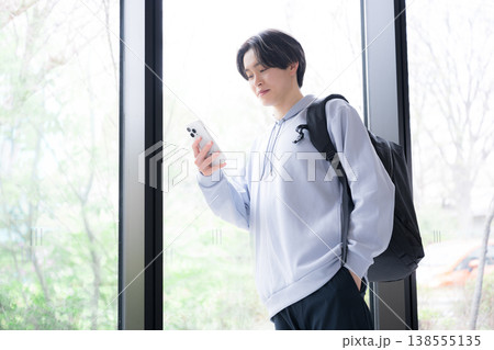 スマートフォンを見る大学生の若い男性の日常と通学シーン スマートフォンを見る大学生の若い男性の日常と通学シーン 138555135