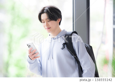 スマートフォンを見る大学生の若い男性の日常と通学シーン スマートフォンを見る大学生の若い男性の日常と通学シーン 138555142