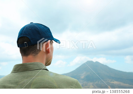 A man stands and looks at Mount Batur in Kintamani Bali A man stands and looks at Mount Batur in Kintamani Bali 138555268