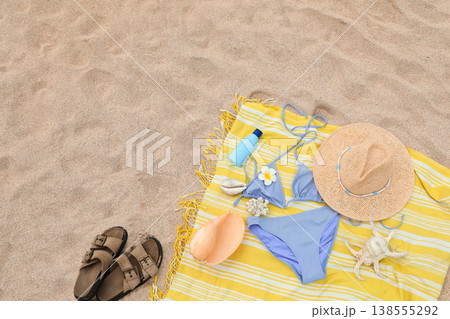 Beach towel with summer items like a bikini, hat, and sunscreen Beach towel with summer items like a bikini, hat, and sunscreen 138555292