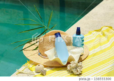 Sunscreen and hat are placed by a poolside in Bali 138555300