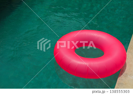A pink float rests next to a clear pool in Bali A pink float rests next to a clear pool in Bali 138555303
