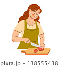 Smiling woman in apron slices a tomato on a board. A cozy home cooking scene featuring healthy food 138555438