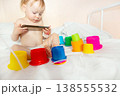 child in hospital lying in bed with mobile phone smiling 138555532