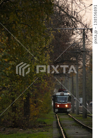 Tram urban public transport rides on rails with green grass and trees. transportation of passengers. 138556891