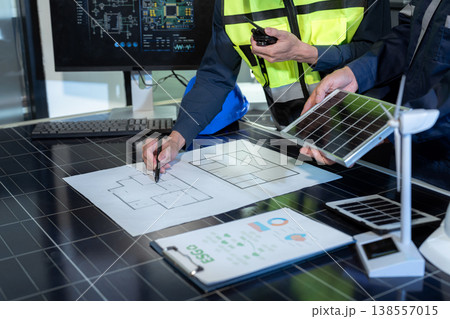 Environmental engineering team meeting with renewable energy model and ESG report in office. Environmental engineering team meeting with renewable energy model and ESG report in office. 138557015