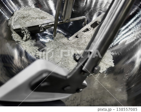 Mixing dry ingredients in a metal bowl while preparing for baking in a kitchen setting 138557085