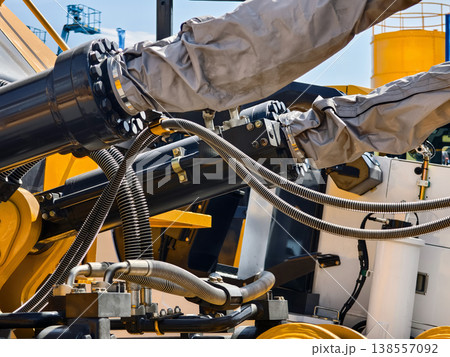 Heavy machinery parts are shown with hydraulic systems and connections at a construction site during daytime Heavy machinery parts are shown with hydraulic systems and connections at a construction site during daytime 138557092