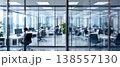 Photo of a modern office space with glass walls and people working at desks, creating a bright and collaborative work environment. 138557130