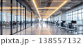 Photo of blurred modern office interior with desks and computers, workspace with glass walls and bright lighting, business environment 138557132