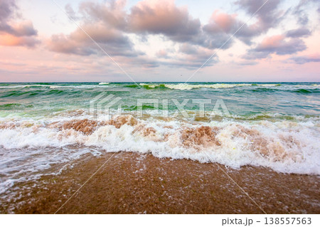 stormy weather on the sandy beach. dramatic sky over the black sea. moody summer landscape in morning light. green waves crashing the shore. majestic cloudscape above the horizon stormy weather on the sandy beach. dramatic sky over the black sea. moody summer landscape in morning light. green waves crashing the shore. majestic cloudscape above the horizon 138557563