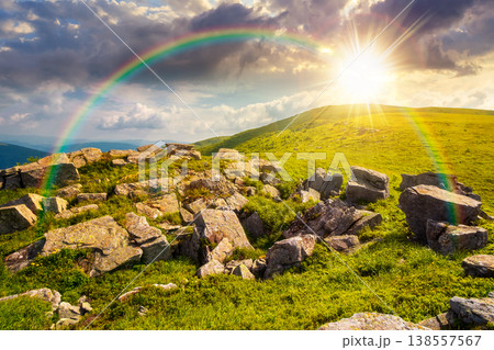 sunset over carpathian mountain summer landscape. alpine meadow with huge stones among the grass on top of the hillside near the peak of mountain range. stunning sky view. weather with rainbow sunset over carpathian mountain summer landscape. alpine meadow with huge stones among the grass on top of the hillside near the peak of mountain range. stunning sky view. weather with rainbow 138557567