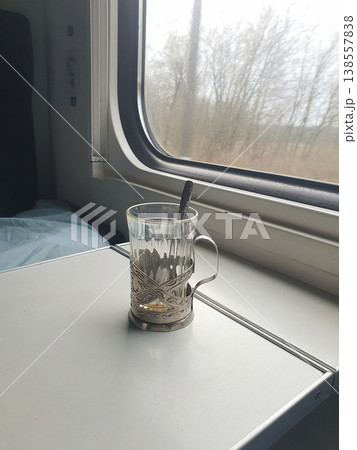 Glass Tea Cup in Metal Holder on Train Table by Window Glass Tea Cup in Metal Holder on Train Table by Window 138557838