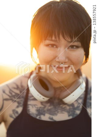 Young woman confidently smiling enjoying golden hour light 138557921