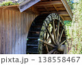苔に覆われた水車が回る木造の水車小屋 138558467