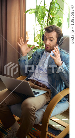 Surprised man with headphones reacting during online coaching video call. Surprised man with headphones reacting during online coaching video call. 138558547