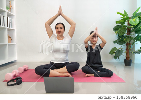 Mother and daughter practicing yoga at home Mother and daughter practicing yoga at home 138558960