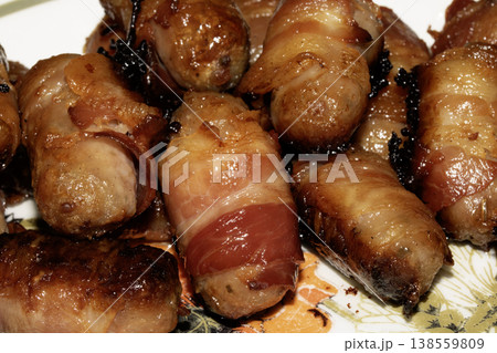 Close up of chipolatas pigs in blankets sausages wrapped in bacon on white background 138559809